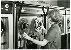 Photograph; Employee Of Deutsche Post Der Gdr Inserting A Magnetic Tape Into An Electronic Data Processing Unit (edva) At The Organization And Computer Center (orz) Of Deutsche Post Der Gdr In Berlin/east Germany. — Tluste Günter